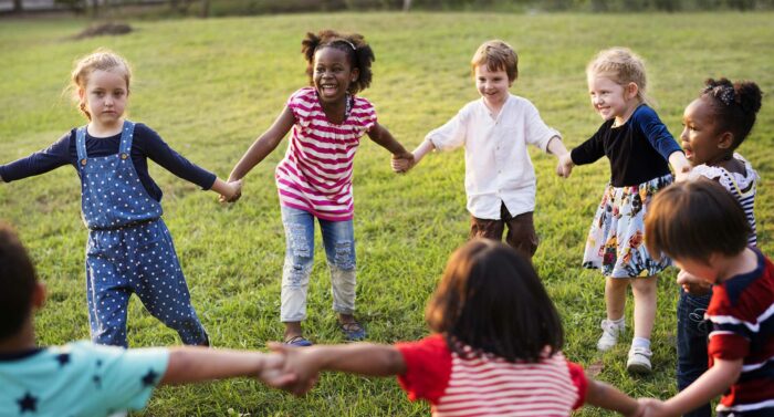 nursey school children playing together outdoors 