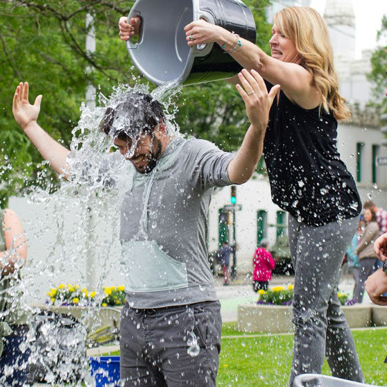 man getting a bucket of ice water thrown over him for charity